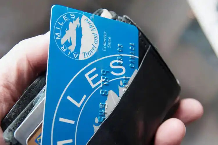 Person holding a bank card while entering details on a laptop.